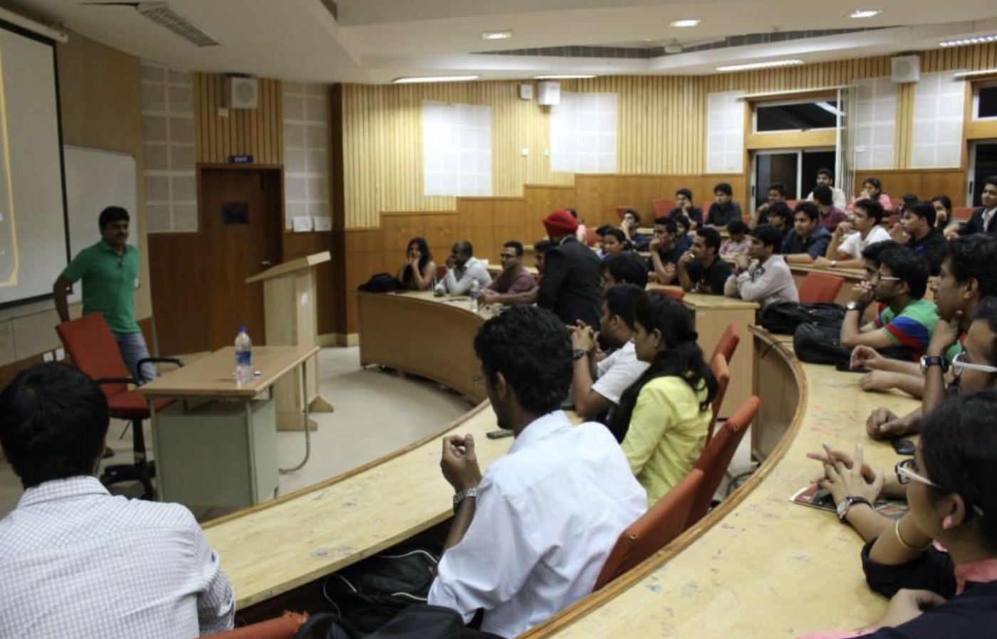 Sheshakanth Munagapati delivering a guest lecture to a full amphitheater of students at IBS Business School